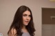 A woman with long brown hair standing in a room.