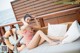 A woman in a pink bathing suit sitting on a couch.