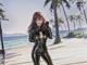 A woman in a black catsuit standing on a beach.