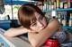 A woman leaning on a counter in front of a bar.