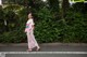 A woman in a pink kimono crossing the street.