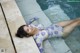 A woman laying on the edge of a swimming pool.