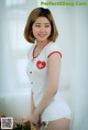 A woman in a white nurse outfit posing for a picture.