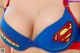 A woman wearing a blue bra with a superman logo on it.